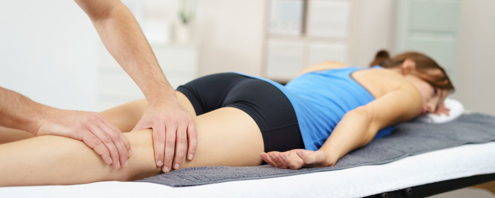 Woman laying down undergoing massage therapy.