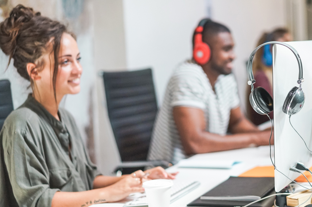 Young trendy team using computers in creative office.