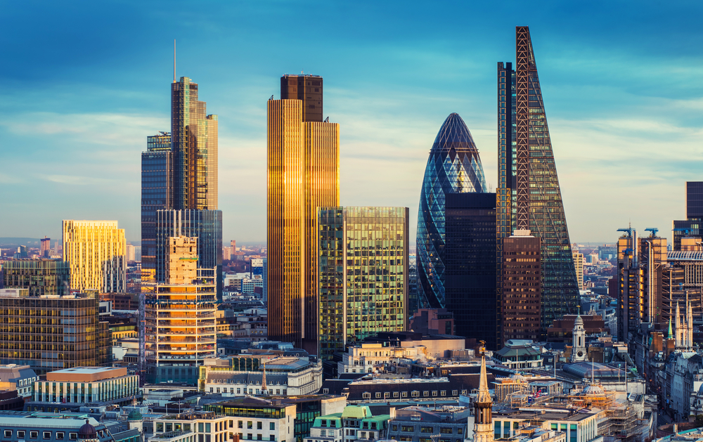 The bank district of central London with famous skyscrapers and other landmarks at sunset with a blue sky.