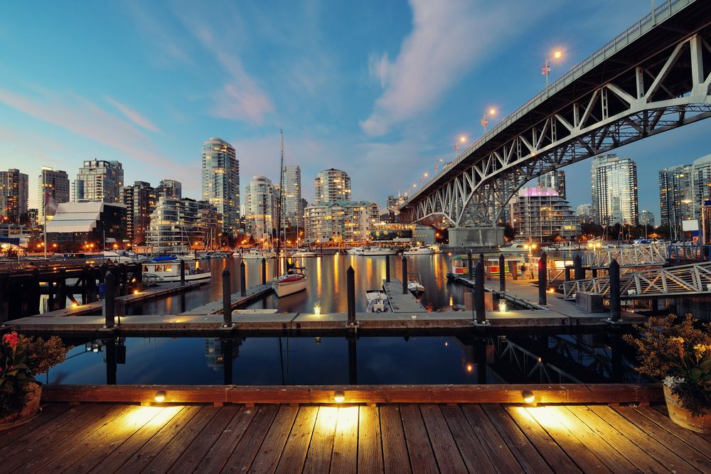 Vancouver False Creek at night with bridge and a boat.