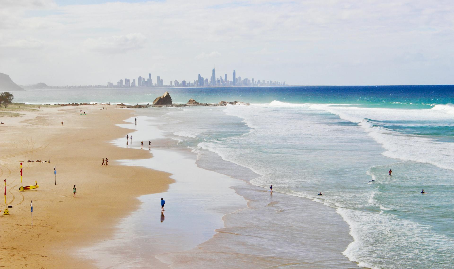 People on the beach at Elephant Lookout, Gold Coast, with the city in the distance.
